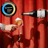 Eine Flasche Thomson & Scott Noughty Sparkling Chardonnay wird in ein Glas eingeschenkt. Im Hintergrund befindet sich ein USA Today Readers' Choice Award-Siegel 2023.